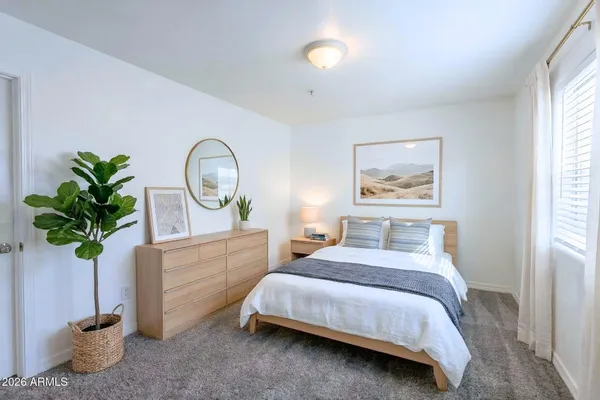 a bedroom with a bed potted plant and a window