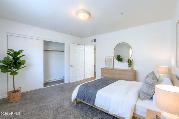 a bedroom with a bed potted plant with the mirror