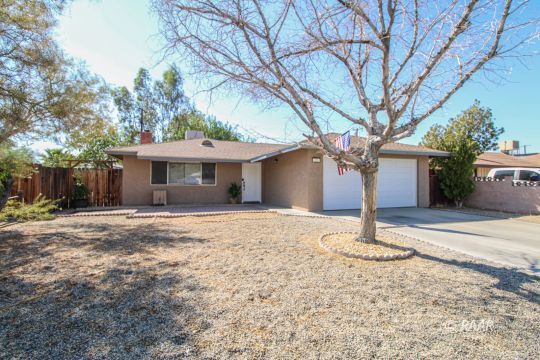 221 South Primrose Street Ridgecrest, CA 93555 - Photo 2 of 29 a front view of a house with a garden and trees
