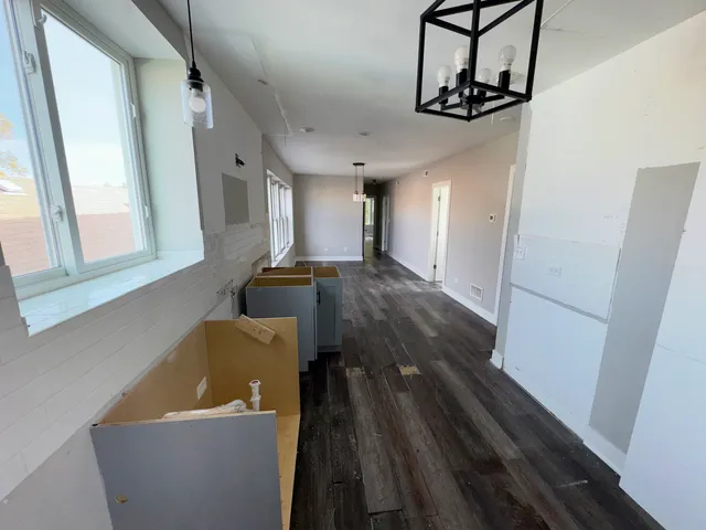 a view of a hallway with wooden floor and staircase