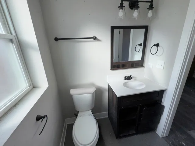 a bathroom with a toilet sink and mirror