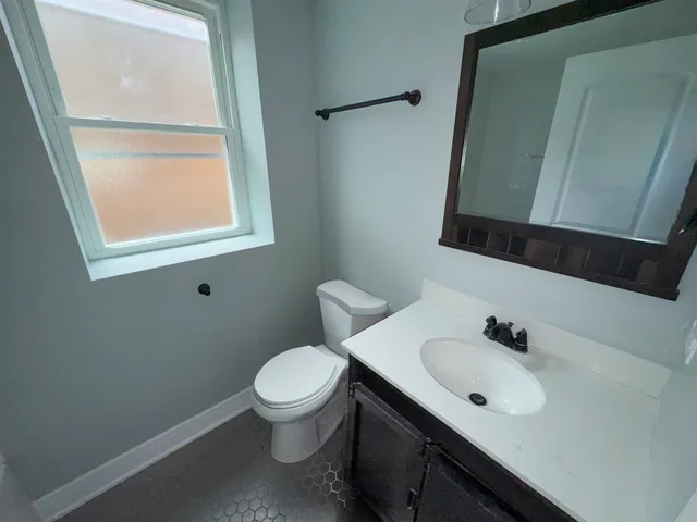 a bathroom with a sink a toilet and a mirror