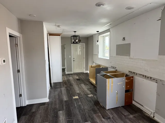 a view of a kitchen with cabinets and wooden floor