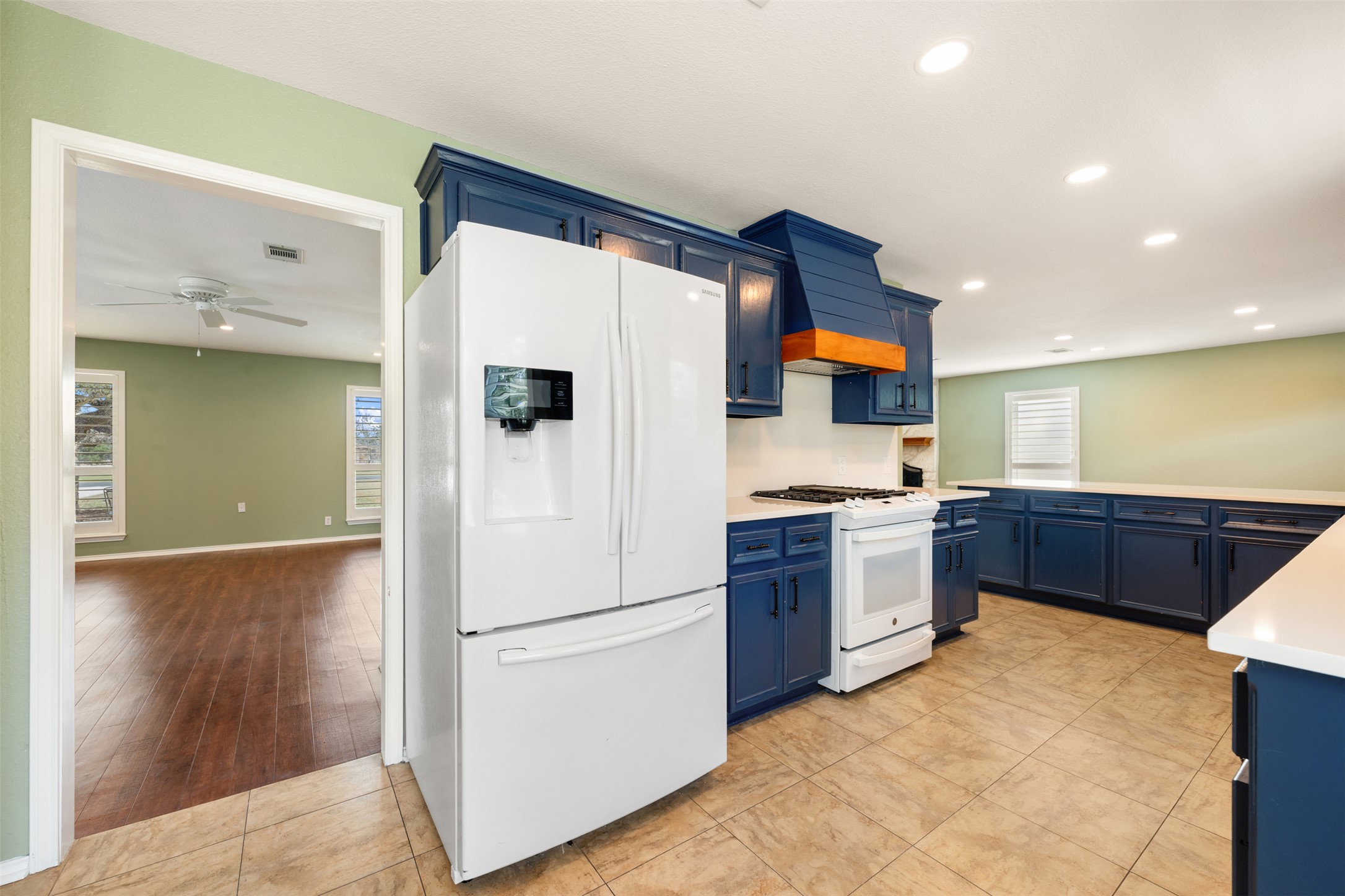 104 Sunset Road Georgetown, TX 78633 - Photo 14 of 40 Kitchen featuring white appliances, blue cabinets, light tile patterned floors, recessed lighting, and a ceiling fan