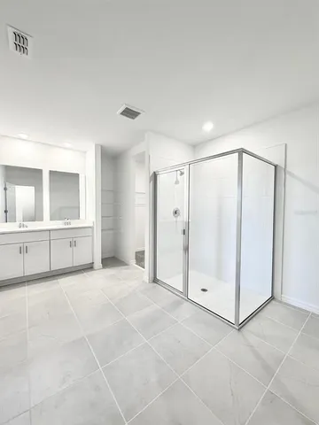 a bathroom with a double vanity sink toilet mirror and bathtub