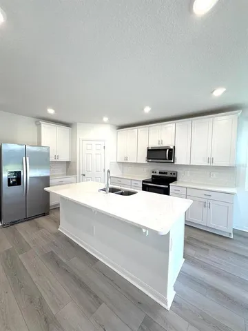 a kitchen with white cabinets and stainless steel appliances