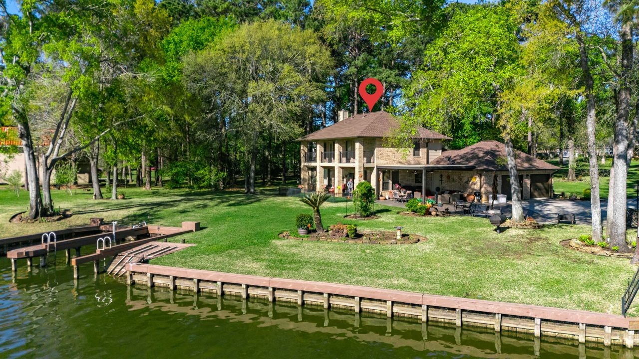 12626 Aries Loop Willis, TX 77318 - Photo 42 of 50 This charming two-story lakeside home features a spacious yard with mature trees, a private dock, and a cozy patio area perfect for outdoor relaxation. Ideal for those seeking a serene waterfront lifestyle.