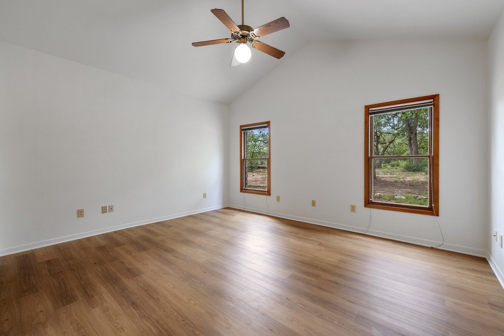 244 Woodway Elgin, TX 78621 - Photo 21 of 40 an empty room with wooden floor chandelier fan and windows