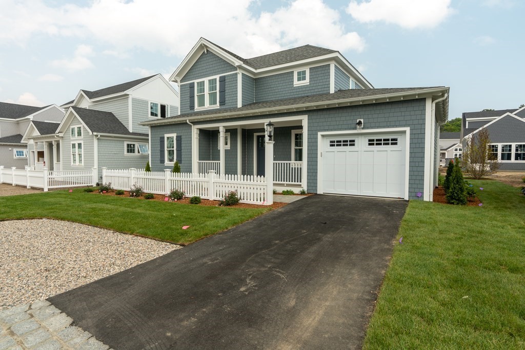 47 Cobblestone Circle Mashpee, MA 02649 - Photo 2 of 25 a front view of a house with a yard and garage