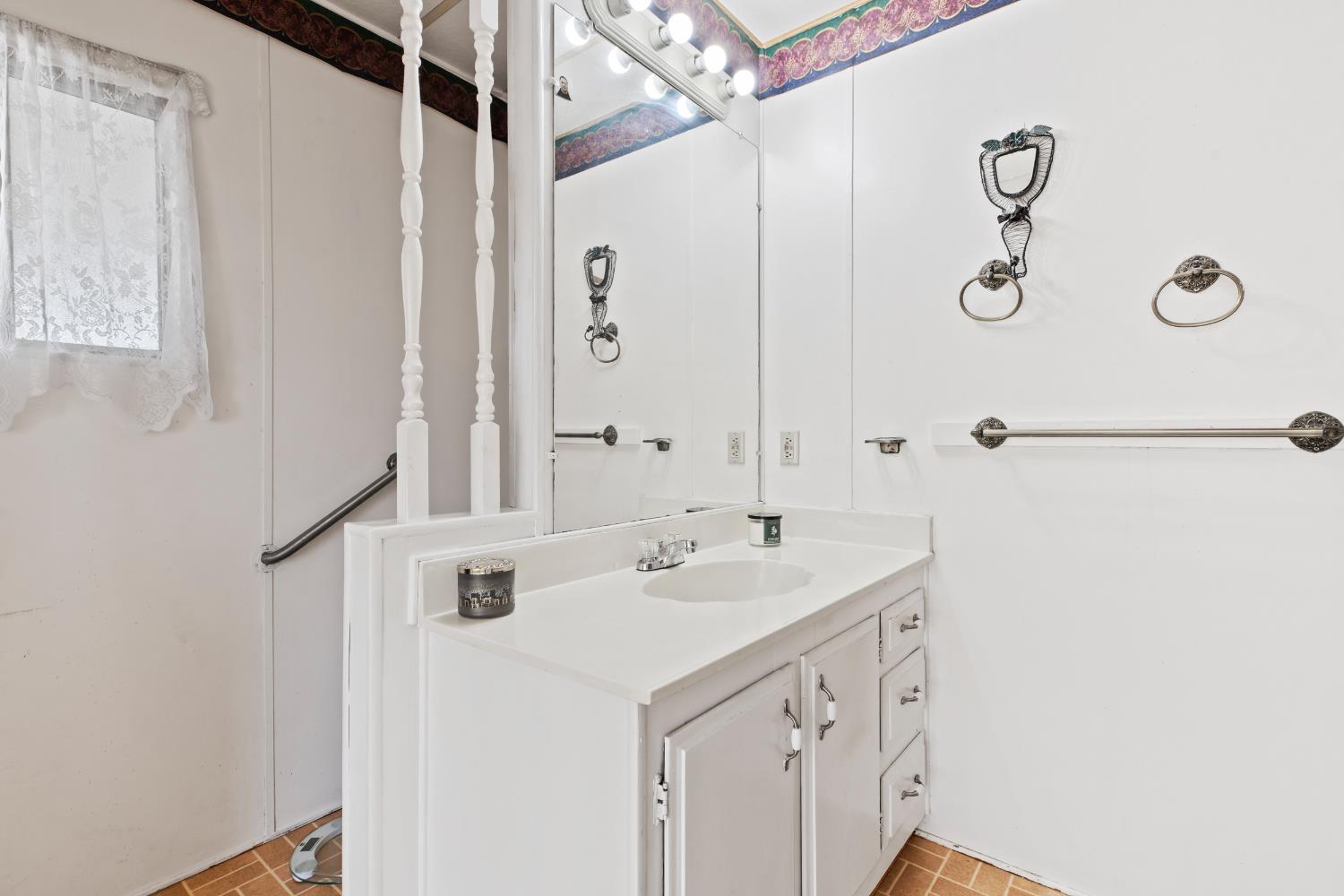 1200 South Carpenter Road, Unit 18 Modesto, CA 95351 - Photo 16 of 30 a bathroom with a sink and a mirror