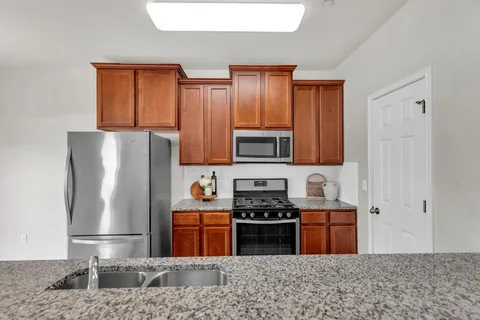 a kitchen with stainless steel appliances granite countertop a refrigerator sink and cabinets