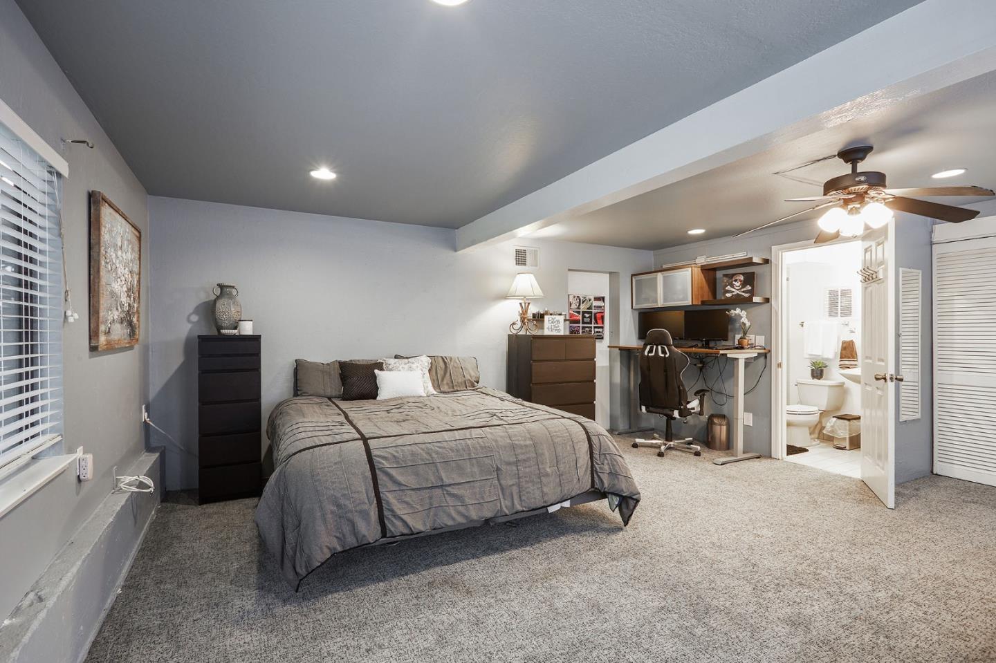 1015 Sycamore Drive Millbrae, CA 94030 - Photo 19 of 26 a bedroom with a bed a chandelier and dresser