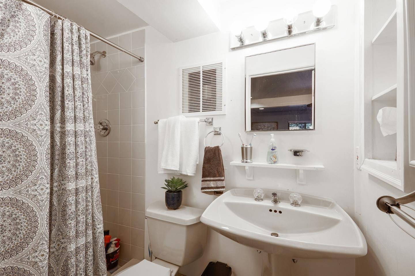 1015 Sycamore Drive Millbrae, CA 94030 - Photo 20 of 26 a bathroom with a sink a mirror and a toilet
