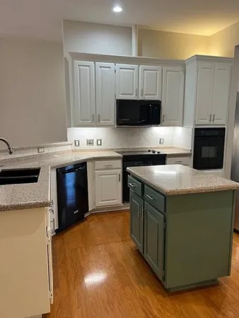 a kitchen with stainless steel appliances granite countertop a stove top oven a refrigerator a sink and a microwave