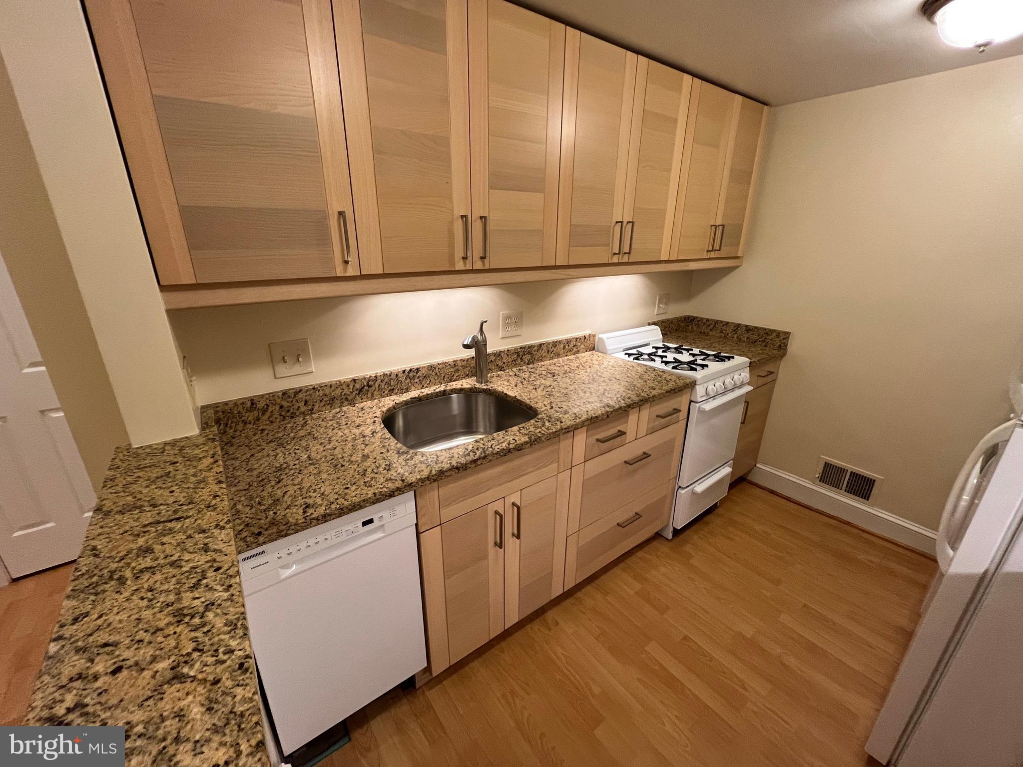 1835 16th Street Northwest, Unit 1 Washington, DC 20009 - Photo 12 of 32 a kitchen with granite countertop a sink a stove and cabinets