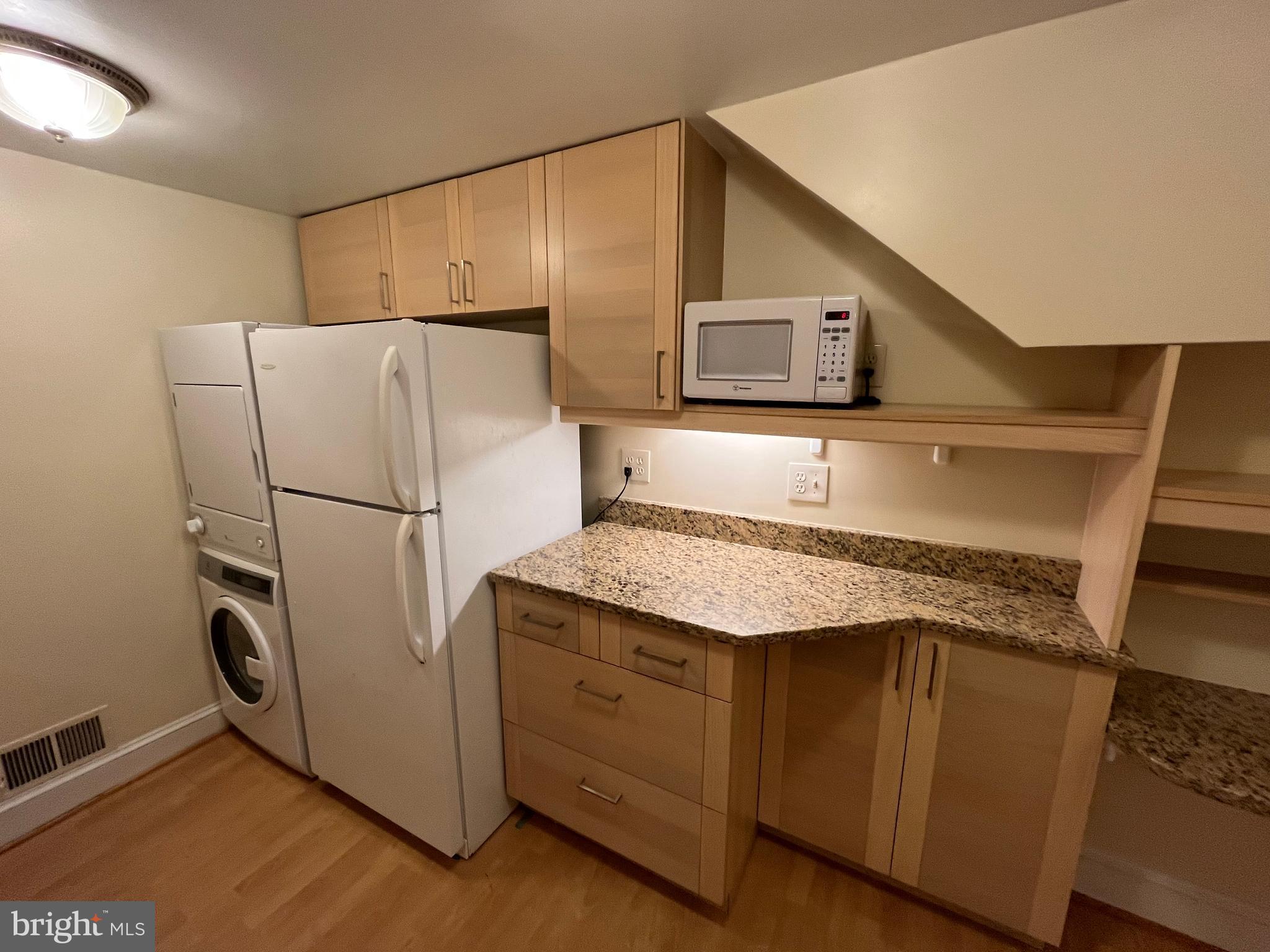 1835 16th Street Northwest, Unit 1 Washington, DC 20009 - Photo 13 of 32 a kitchen with stainless steel appliances granite countertop a refrigerator a stove and a sink with wooden floor