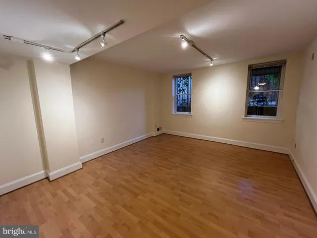 a view of empty room with wooden floor