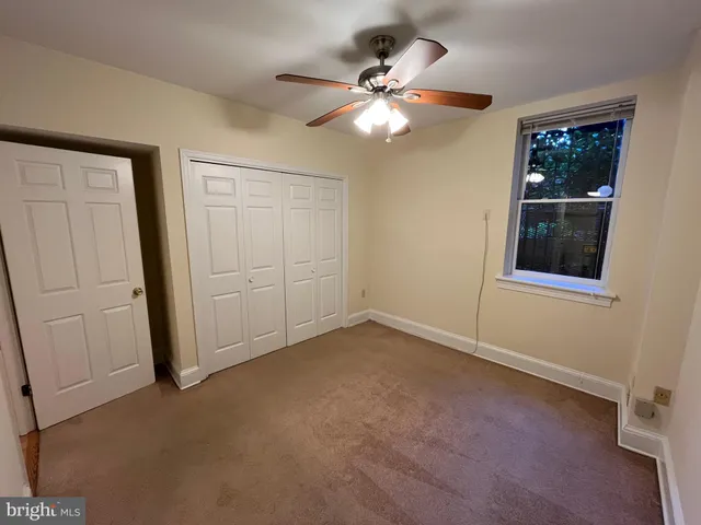 en empty room with windows and fan