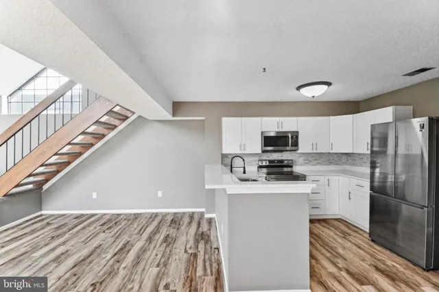 a kitchen with stainless steel appliances a refrigerator and a stove top oven