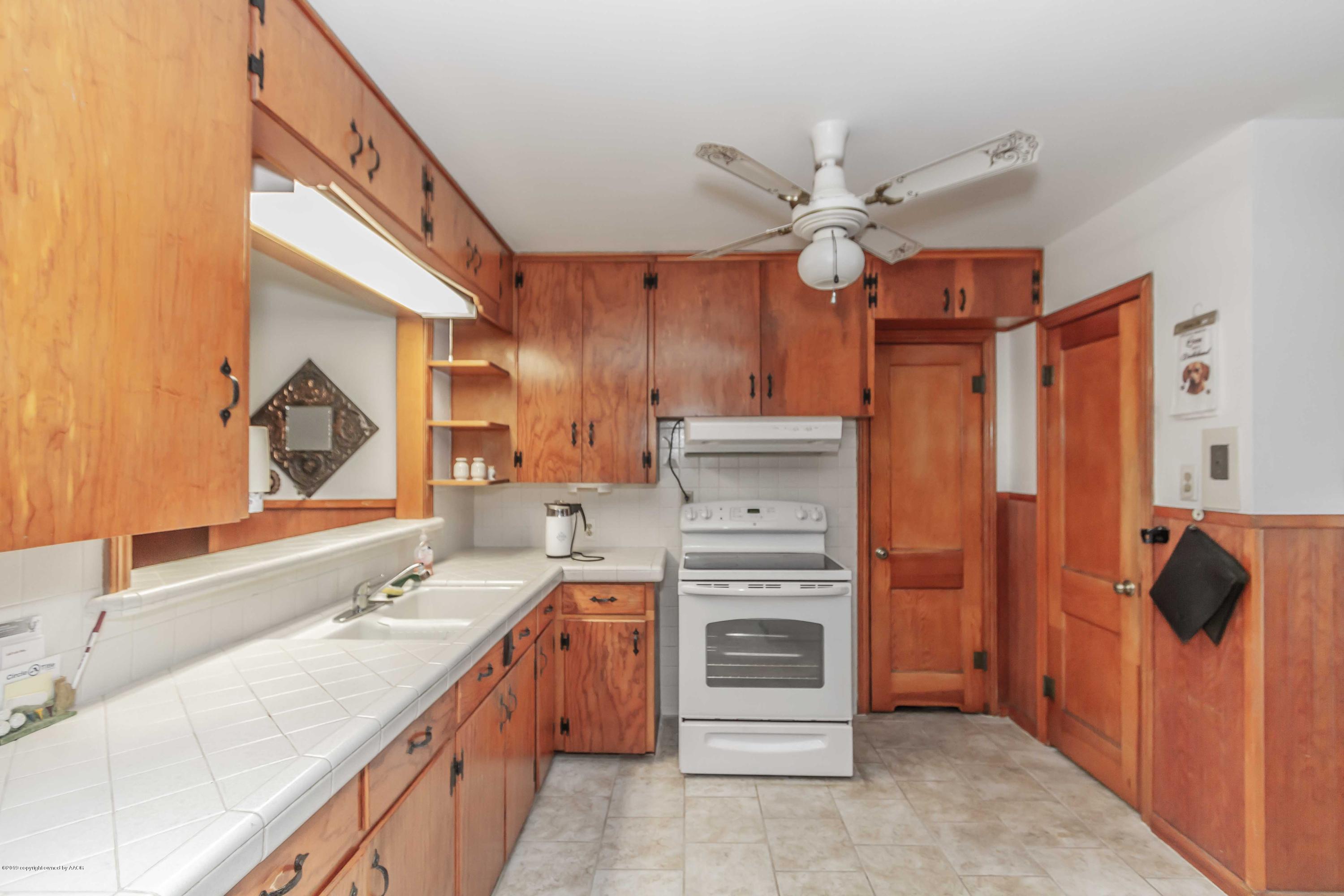 3613 Cline Road Amarillo, TX 79110 - Photo 11 of 36 a kitchen with granite countertop a sink and a refrigerator