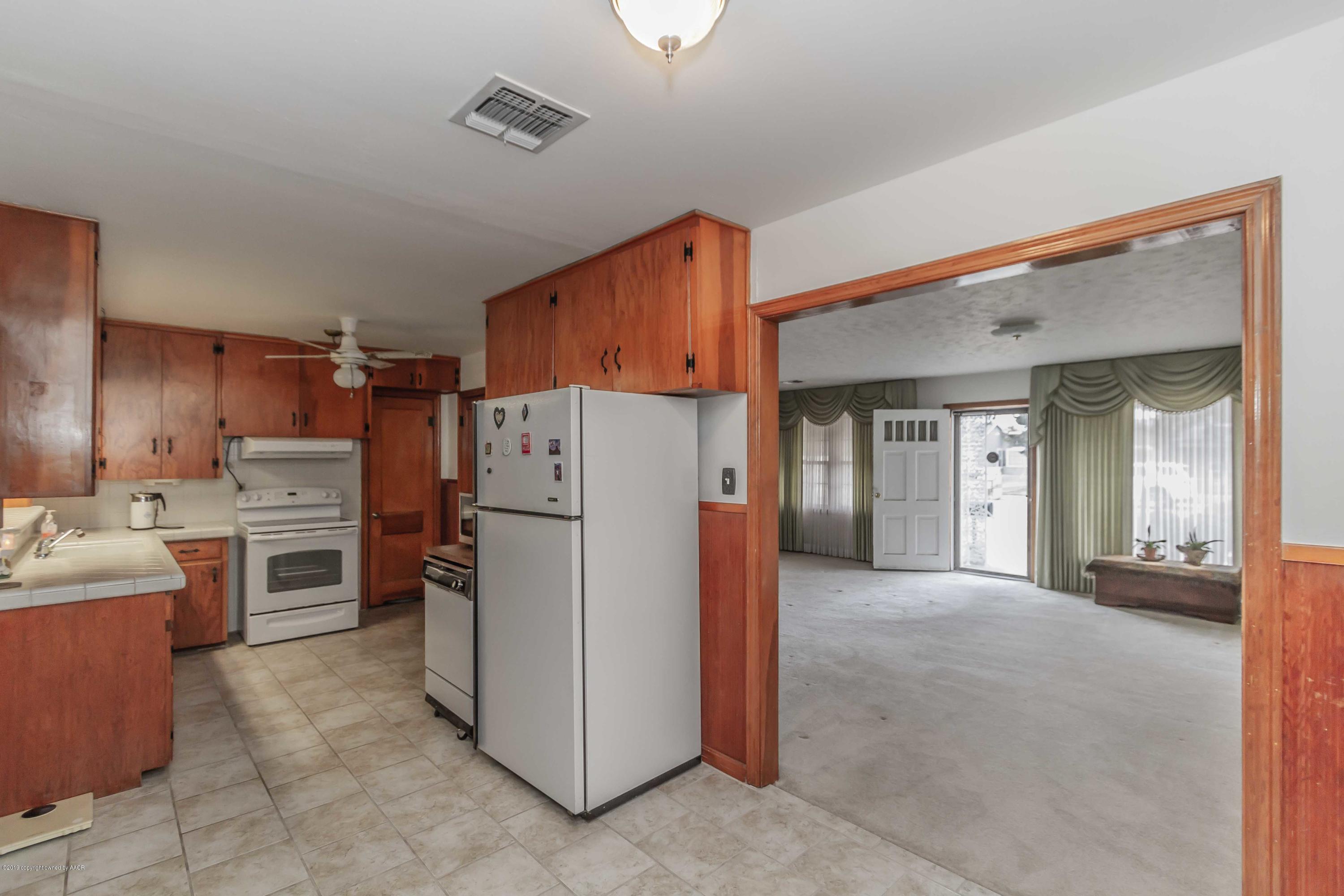 3613 Cline Road Amarillo, TX 79110 - Photo 14 of 36 a kitchen with refrigerator and cabinets