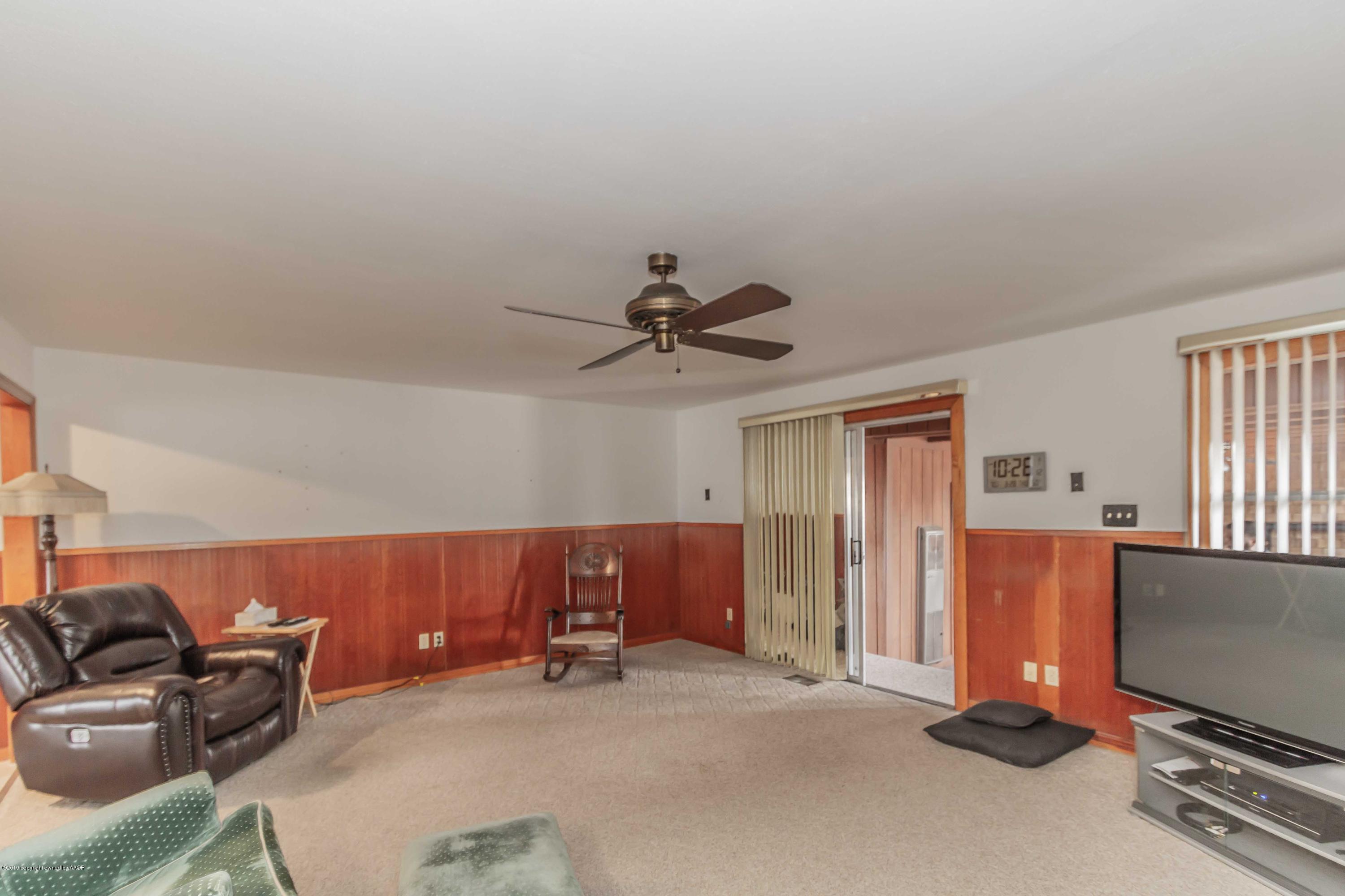 3613 Cline Road Amarillo, TX 79110 - Photo 16 of 36 a living room with furniture gym equipment and a flat screen tv