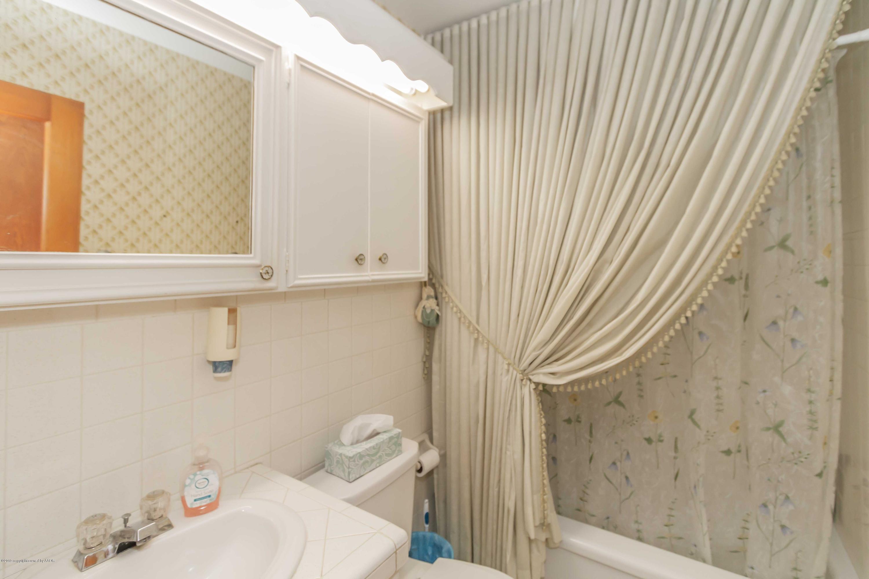 3613 Cline Road Amarillo, TX 79110 - Photo 17 of 36 a bathroom with a sink a toilet and shower curtain