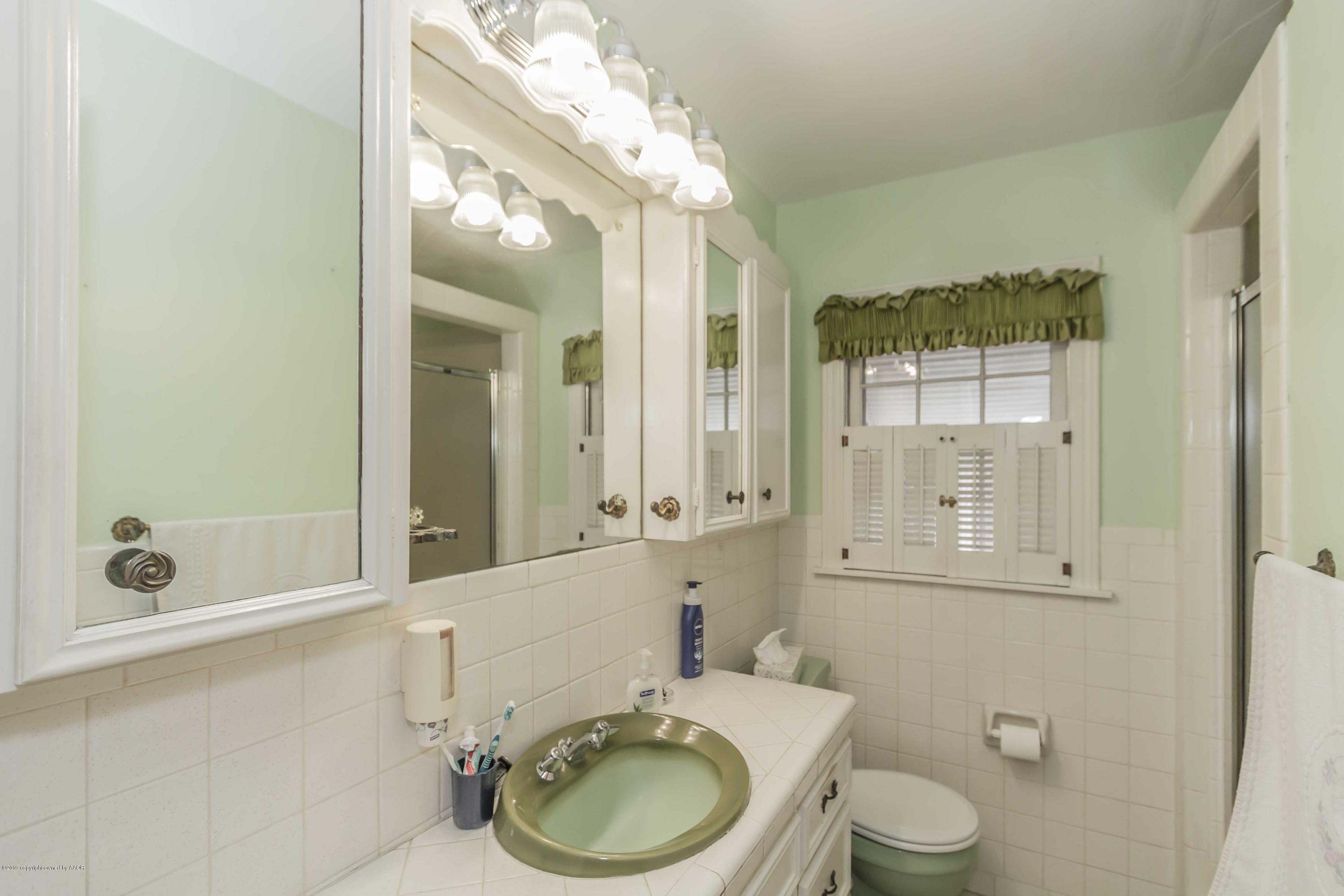 3613 Cline Road Amarillo, TX 79110 - Photo 19 of 36 a bathroom with a granite countertop toilet a sink and bathtub