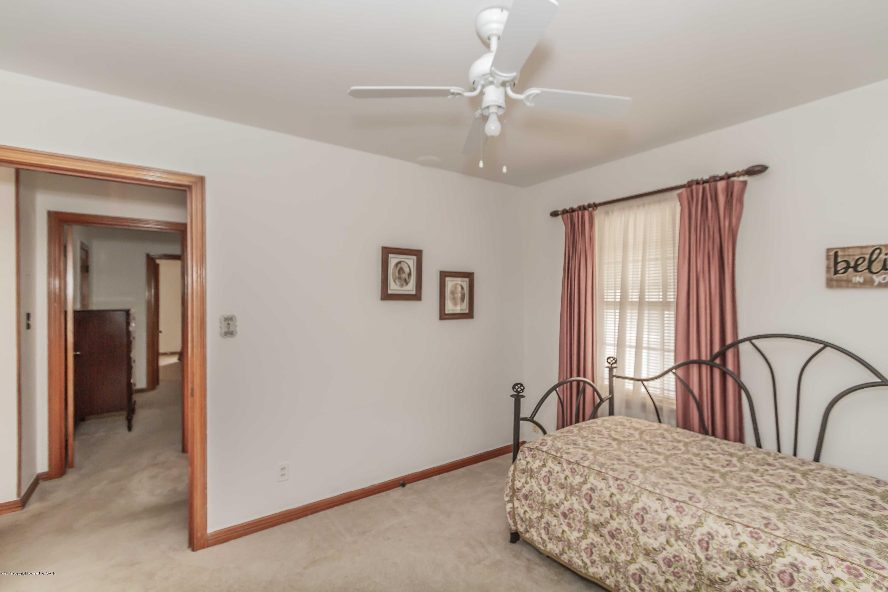 3613 Cline Road Amarillo, TX 79110 - Photo 30 of 36 a bedroom with a bed and a table with mirror