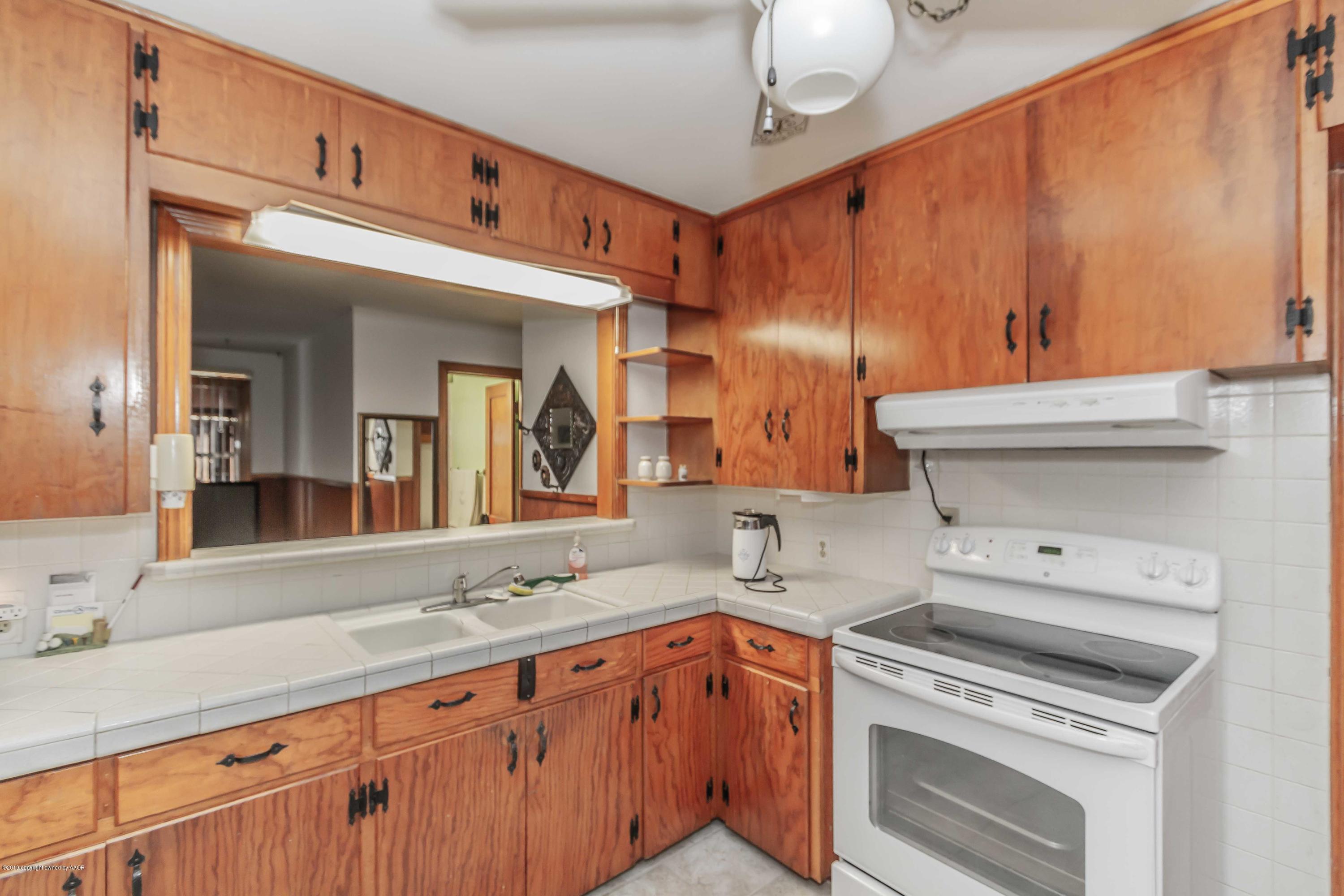 3613 Cline Road Amarillo, TX 79110 - Photo 10 of 36 a kitchen with granite countertop a sink stainless steel appliances wooden floor and cabinets