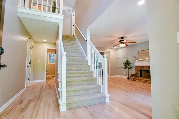 a view of a hallway with wooden floor and a living room