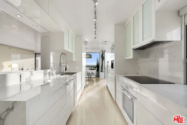 a large kitchen with kitchen island a large counter space a sink stainless steel appliances and cabinets