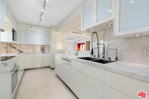 a kitchen with granite countertop a sink stainless steel appliances and cabinets