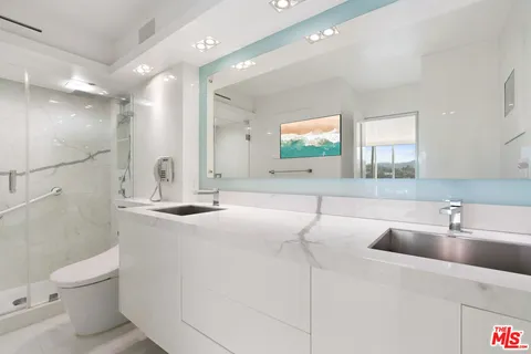 a bathroom with a sink a toilet and a mirror