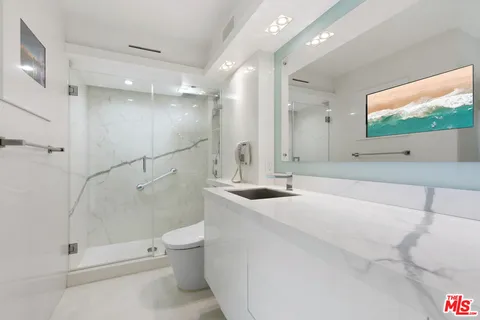 a bathroom with a sink a toilet and shower