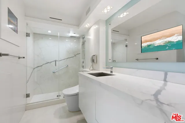 a bathroom with a sink a toilet and shower