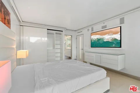 a bedroom with a large window and a flat screen tv