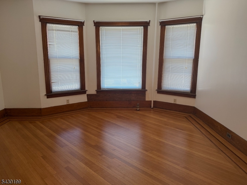 72 Baldwin Place, Unit 2 Bloomfield, NJ 07003 - Photo 7 of 24 an empty room with wooden floor and windows