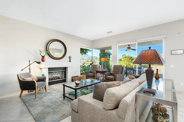 a living room with fireplace furniture and a large window