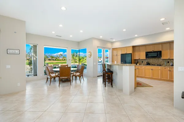 a dining room with furniture and a floor to ceiling window