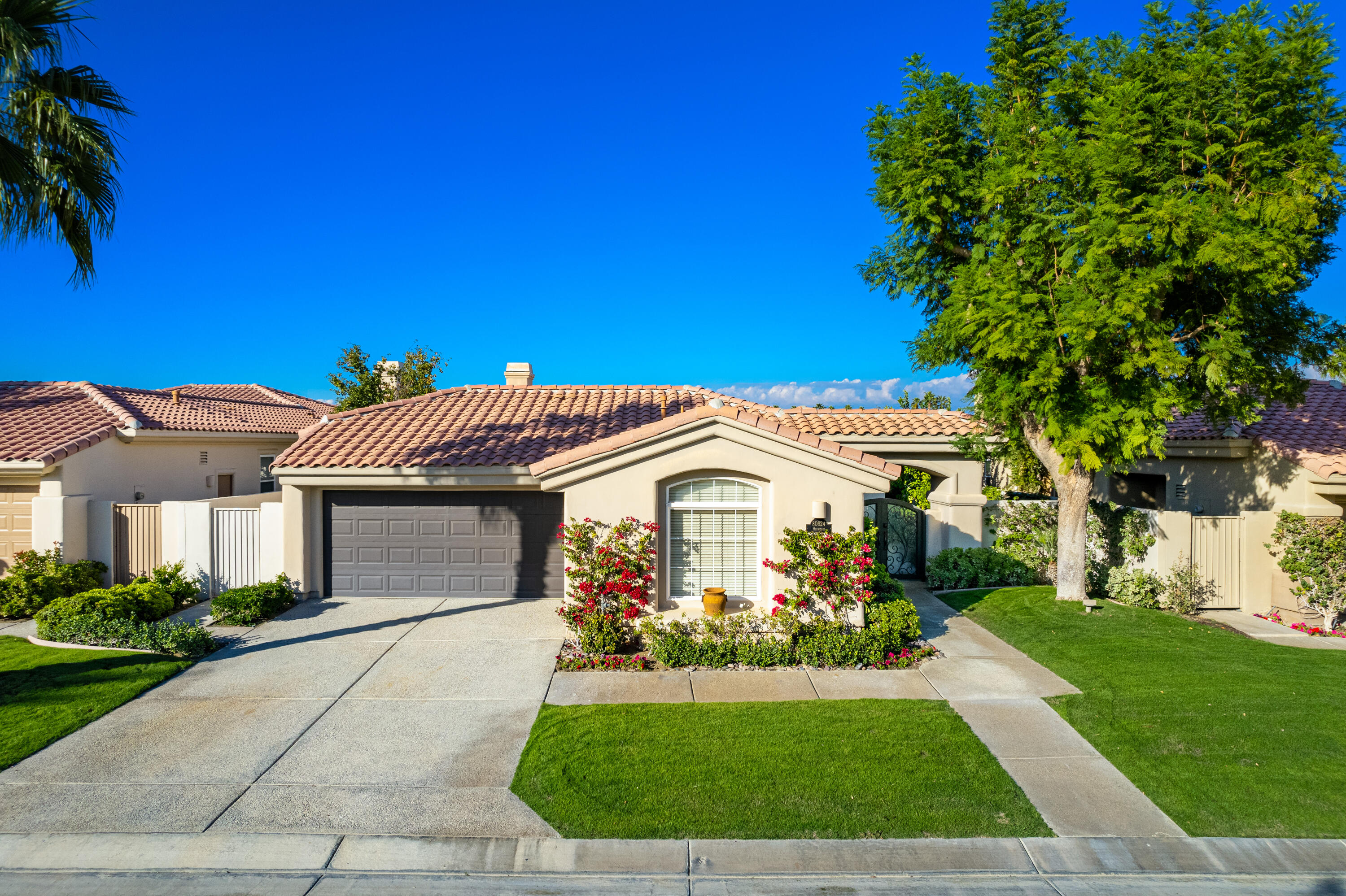 80824 Hermitage La Quinta, CA 92253 - Photo 3 of 49 a front view of a house with a garden and plants