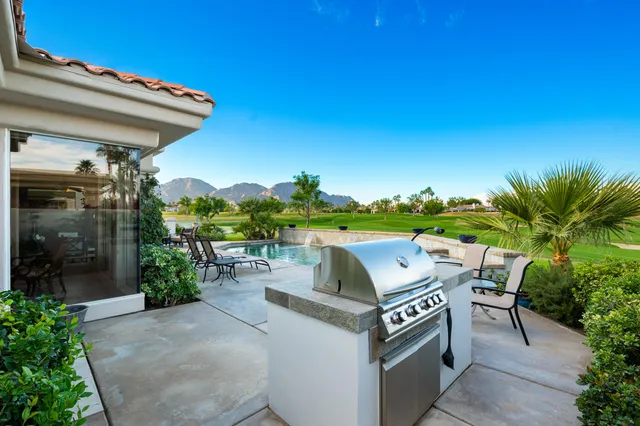 a view of a swimming pool and lounge chairs in back yard of the house