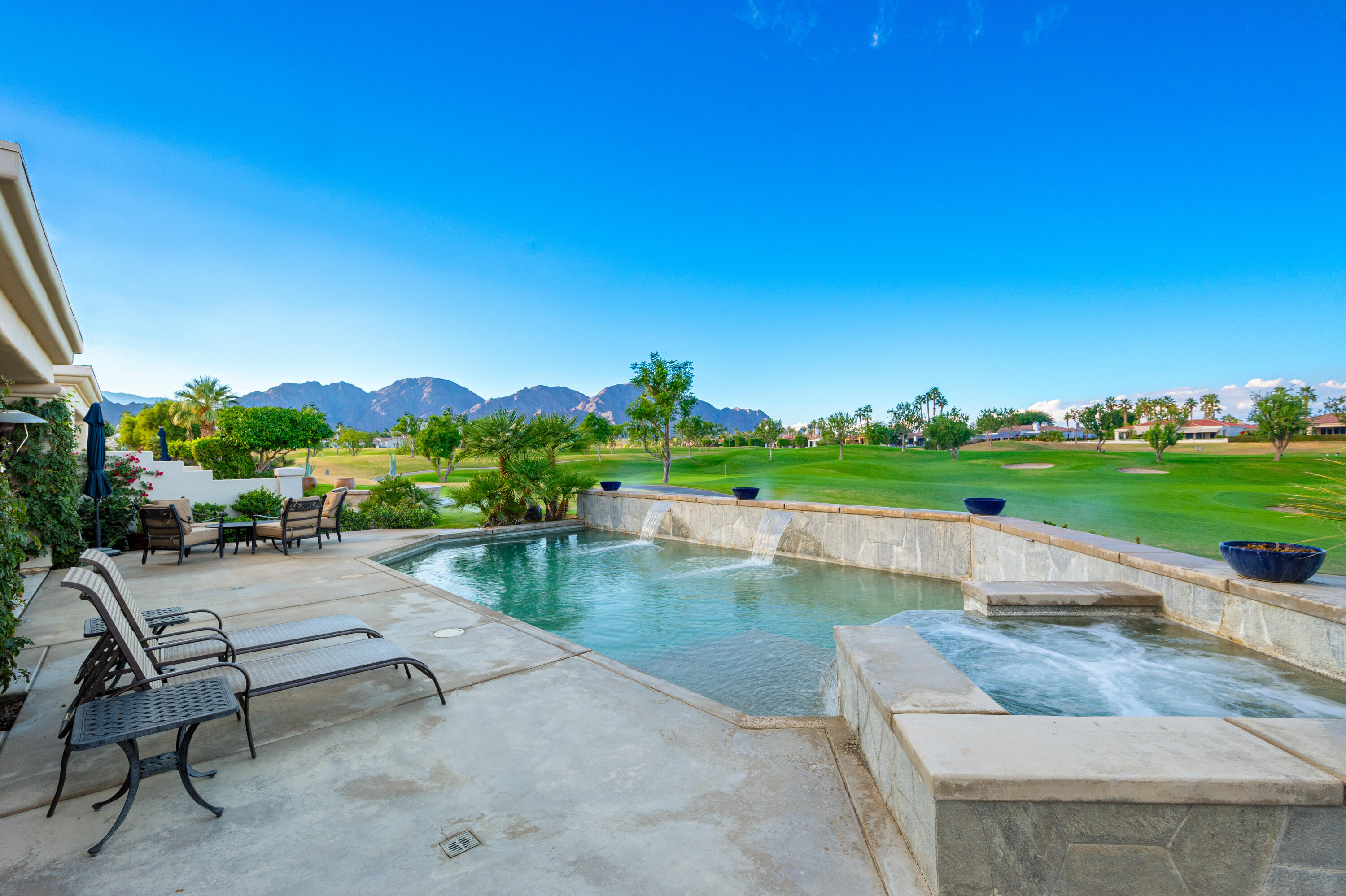 80824 Hermitage La Quinta, CA 92253 - Photo 35 of 49 a view of a swimming pool and lounge chairs in back yard of the house