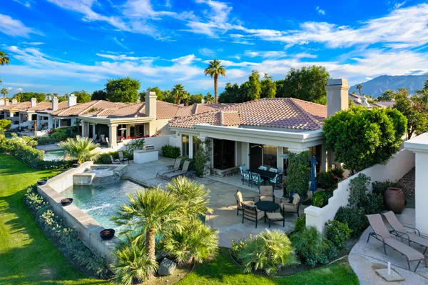 a view of a house with pool and chairs