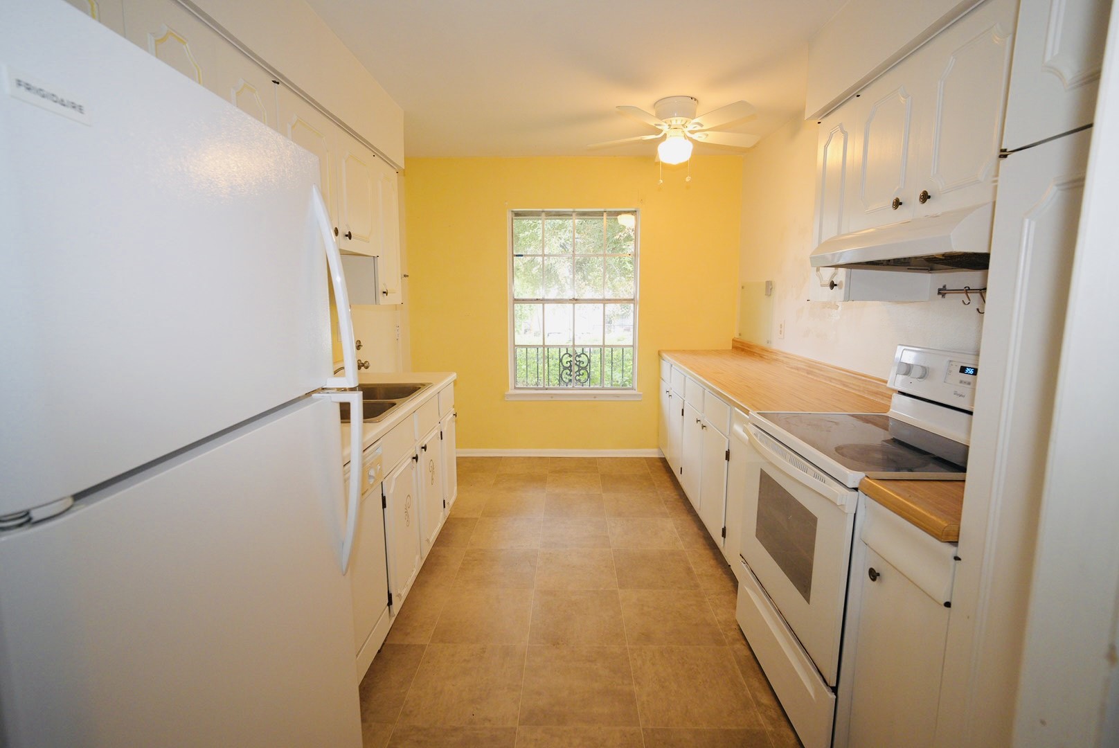 7600 Burgoyne Road, Unit 250 Houston, TX 77063 - Photo 13 of 14 Bright and inviting, this kitchen features classic white cabinetry, appliances, and a warm, sunny ambiance perfect for culinary creativity and cozy gatherings.