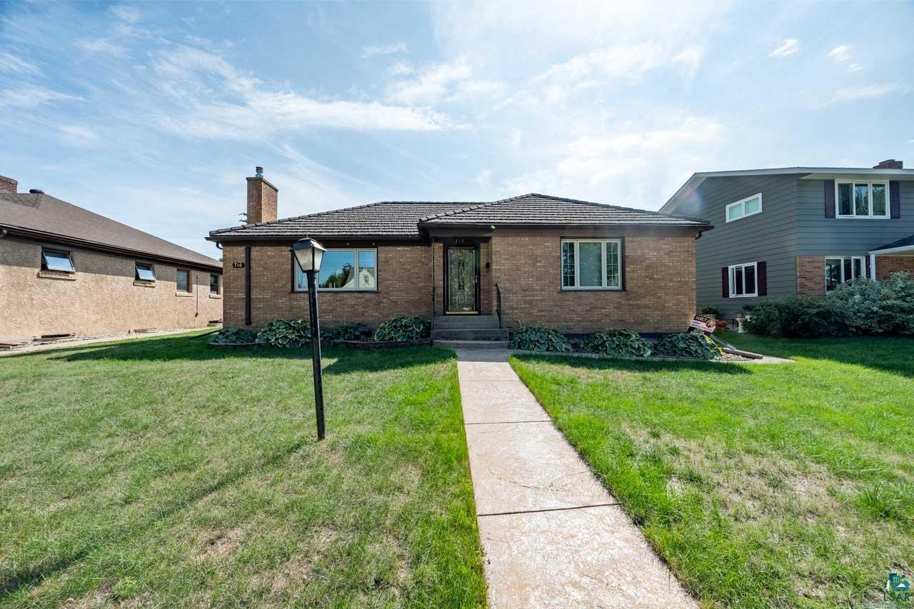 716 South 9th Street Virginia, MN 55792 - Photo 39 of 43 Brick exterior with a dark shingle roof and a concrete walkway