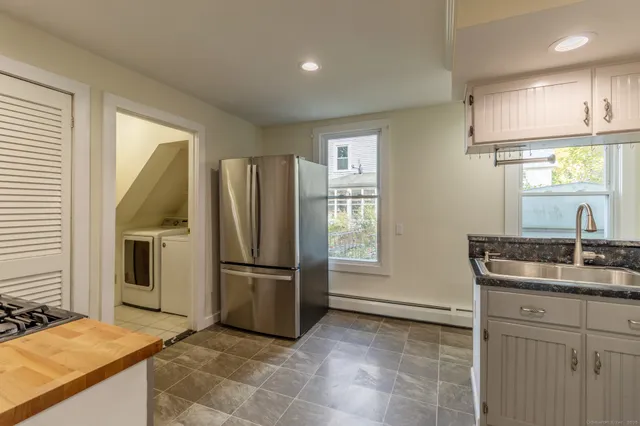 a kitchen with stainless steel appliances granite countertop a refrigerator and a sink