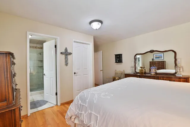 a bedroom with a large bed and a mirror