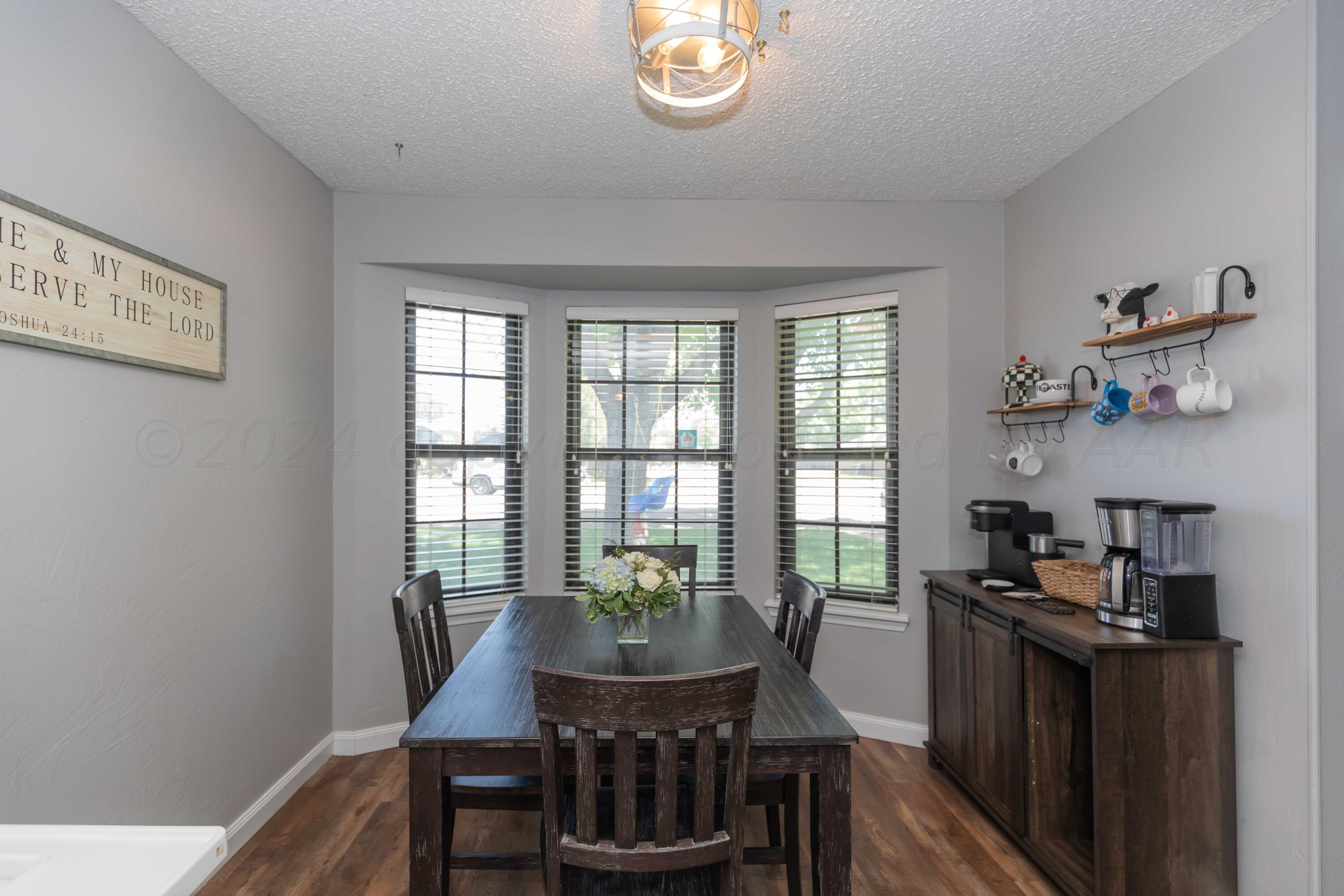5804 Oakman Drive Amarillo, TX 79109 - Photo 12 of 48 a view of a dining room with furniture a chandelier and wooden floor