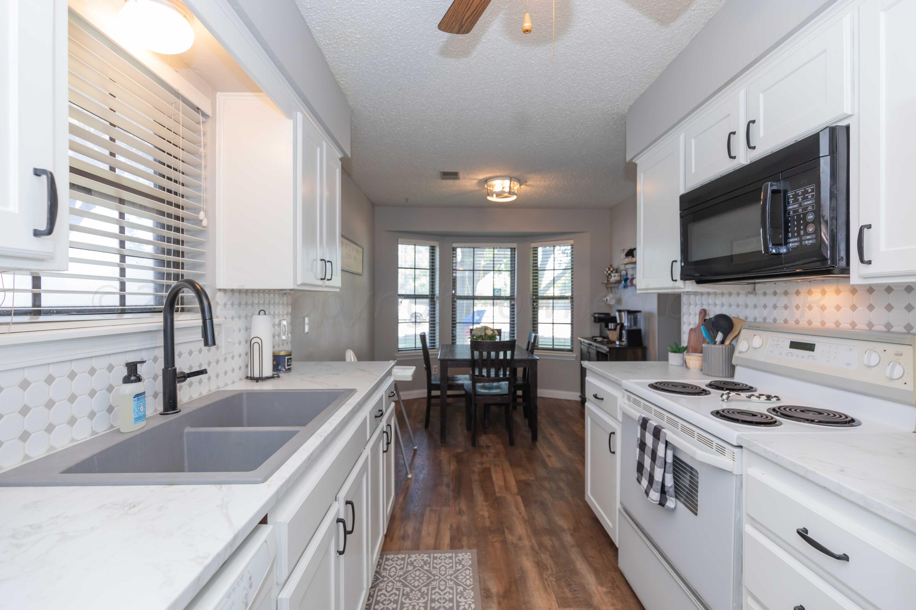 5804 Oakman Drive Amarillo, TX 79109 - Photo 13 of 48 a kitchen that has a sink a stove and cabinets